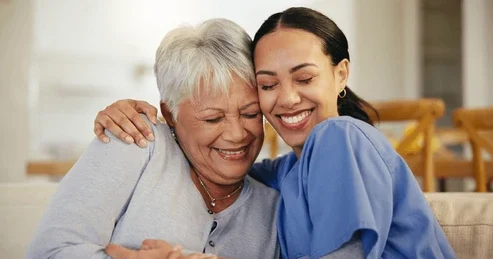 Happy Nurse hugging a elderly woman